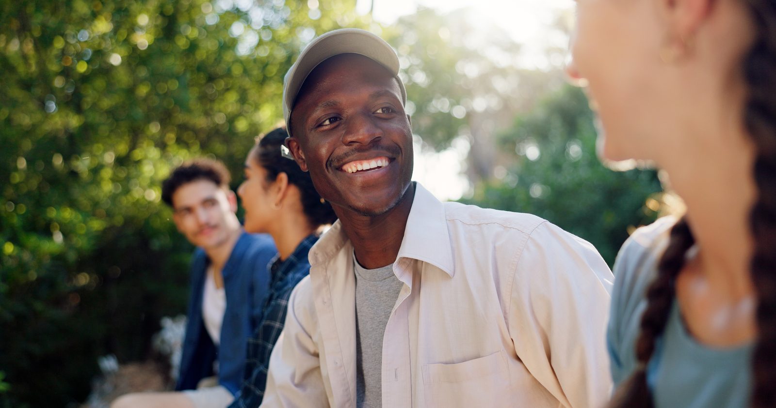 A smiling young man outdoors with a group of friends