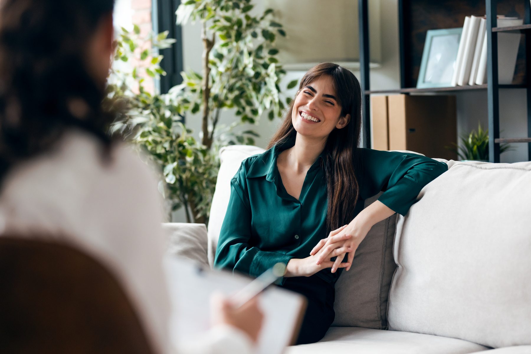 A smiling woman talking with her therapist during a CBT session