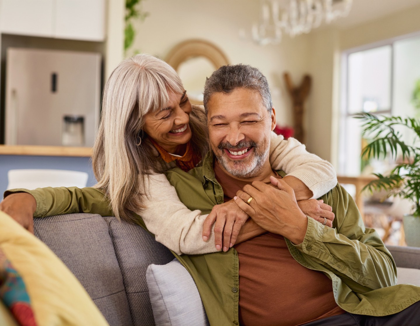 A smiling couple embracing on a sofa at home